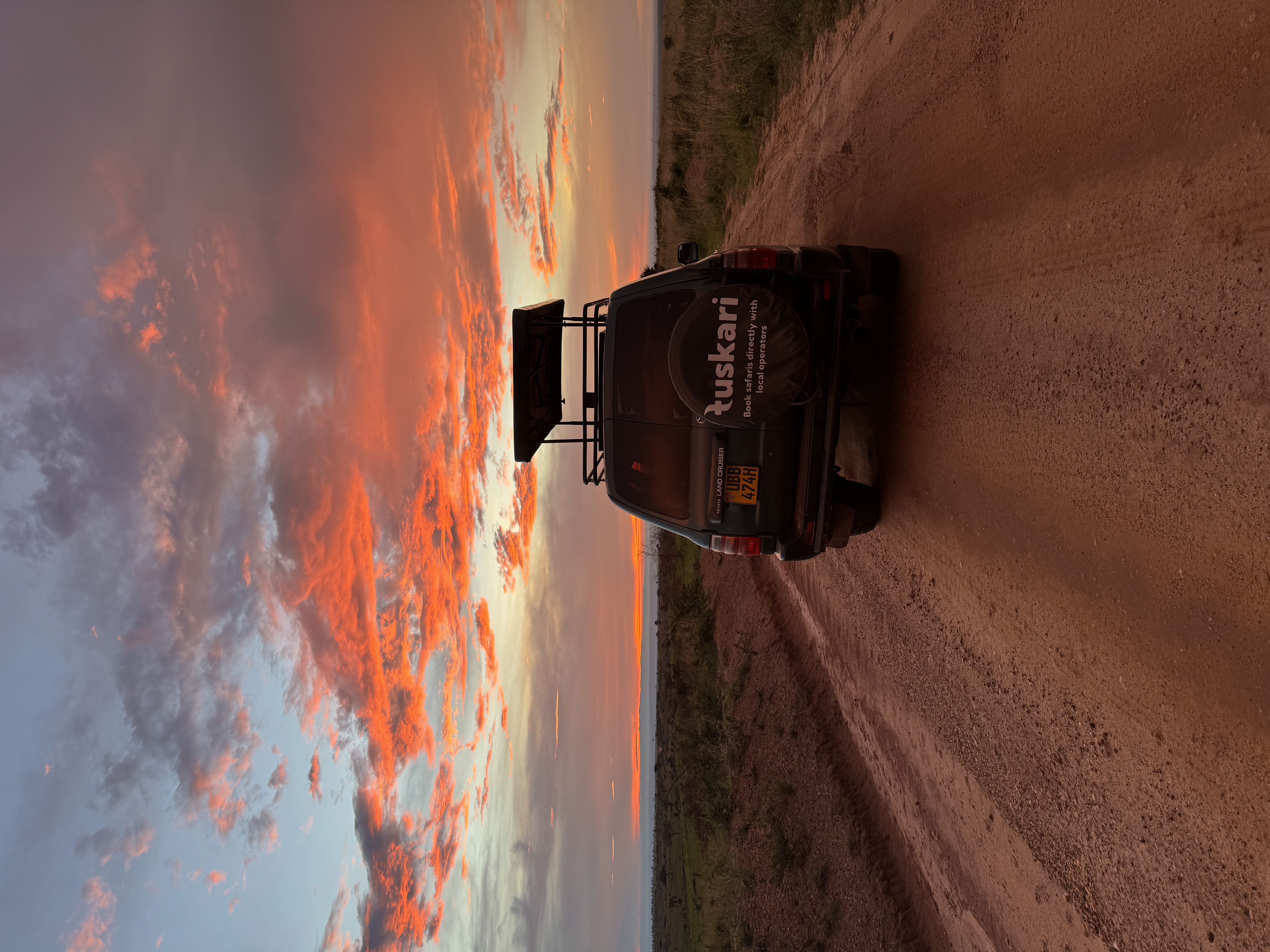 Tuskari safari vehicle on a red road at sunset